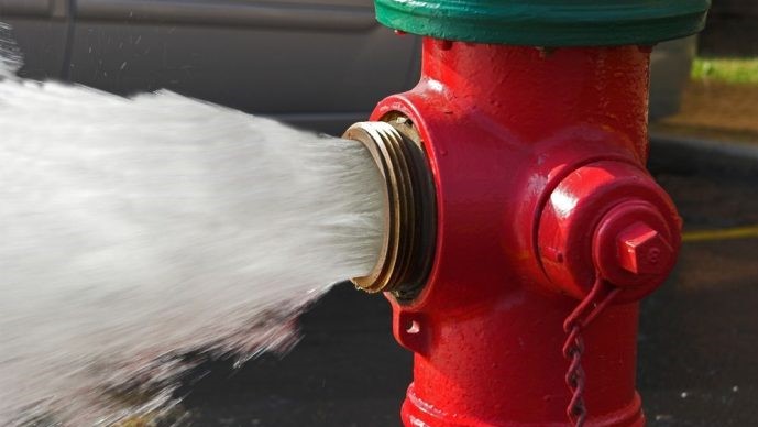 Ambulante preleva acqua dall'idrante comunale per pulire il tratto della pubblica strada adiacente al proprio esercizio di vendita. Reato o illecito amministrativo?