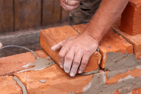 Muratore dopo una giornata di lavoro sotto il sole alla guida della propria a...