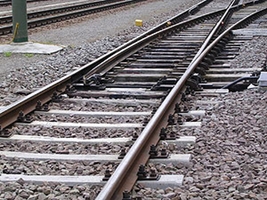 Parcheggia l'auto sui binari del treno in prossimità di un passaggio a livello.