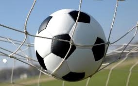 Un ragazzino con una pallonata infrange una vetrina di un com...